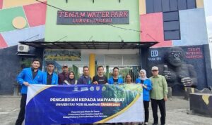 Tim yang terdiri atas para dosen dan mahasiswa berpose bersama di depan gerbang masuk wisata AIr Terjun Temam - Lubuklinggau.